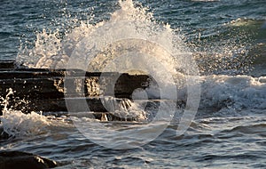 Stormy windy sea waves splashing on a rocky seashore