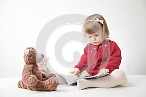 Story time. Little girl playing school with toys teddy bear and doll.  children education and development, happy childhood