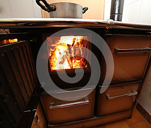 Stove a wood-burning Stove with fire lit in the old mountain hom photo