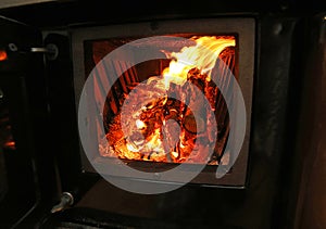 Stove a wood-burning Stove with fire lit in the old mountain hom photo