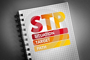 STP - Situation Target Path acronym on notepad, business concept background