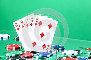 Straight combination under the water drops and falling poker chips against green background. Online gambling. Betting.