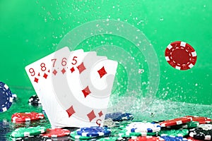 Straight combination under the water drops and falling poker chips against green background. Online gambling. Betting.