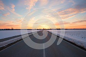 Straight country road in winter landscape at sunset, Brunnthal village, upper bavaria