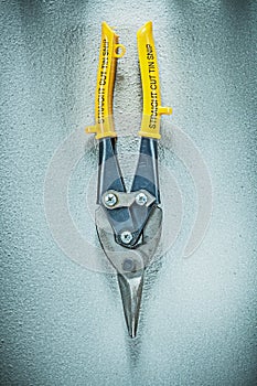 Straight cut tin snips on concrete surface construction concept