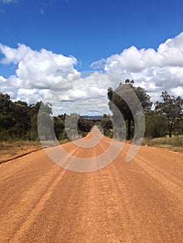 Straight dirt road stretching through Australian countryside