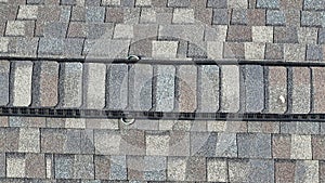 Straight down aerial over earthtone shingles on roof with two roof anchor rings