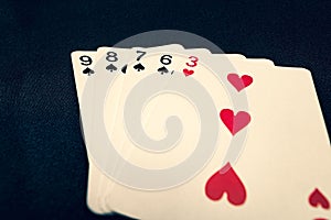 Straight flush of spades on black background