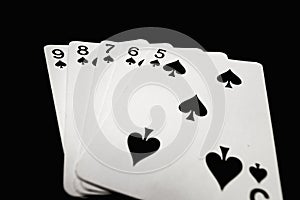 Straight flush of spades on black background