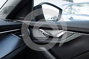 Straight lines design in an interior car with metal door handle and side mirror