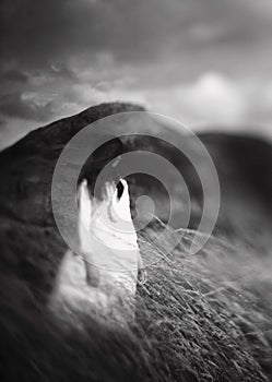 Mysterious monochrome girl in white dress shot with Lensbaby in mountains. Art shot photo