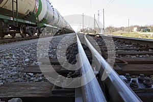 Straight polished railway road with oil tanks