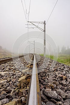 Straight railroad on a foggy morning, vertical shot