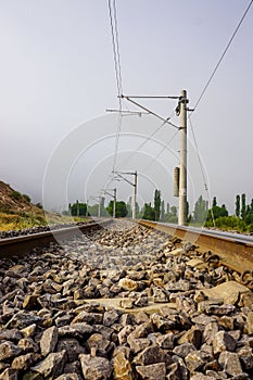 Straight railroad on a foggy morning, vertical shot