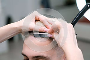 Straight razor. haircut process of blond young man in barbershop salon