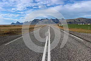 Straight road with mountains in the background