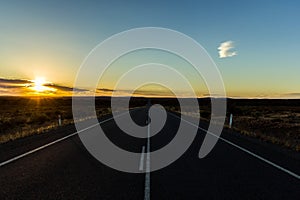Straight road through the nullarbor dessert of Australia at sunset, South Australia, Australia