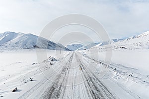 Straight road in snow mountain