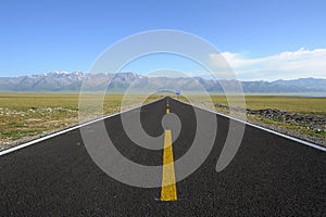 Straight road with snow mountains