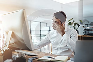 The strain of a long day has knocked him out. Shot of a young businessman looking stressed out and tired while working