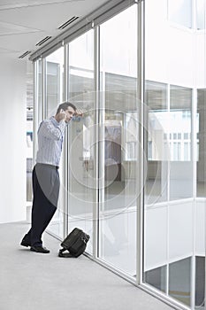 Strained Businessman Using Cellphone In Office