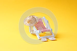 Strand accessoires and sun lounger on yellow background