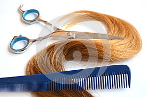 Strand of hair with scissors and comb for haircut