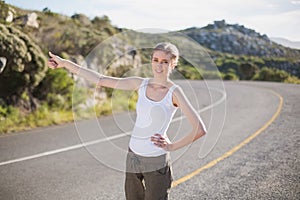 Stranded woman hitching a lift and smiling at camera