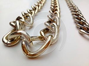 Strands of golden color iron chain isolated by a white background