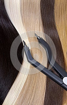 Strands of natural hair in different colors for extensions with tools. Hair color palette.