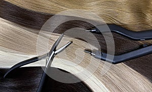 Strands of natural hair in different colors for extensions with tools. Hair color palette.