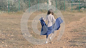 Strange skinny underage girl with towel in her hands from the slums dancing near restricted area. concept: destitute abandoned chi