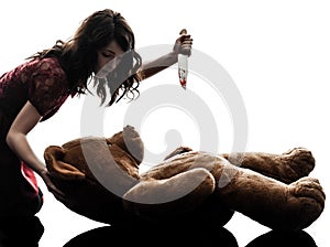 Strange young woman killing her teddy bear silhouette