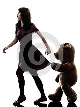 Strange young woman and vicious teddy bear silhouette photo