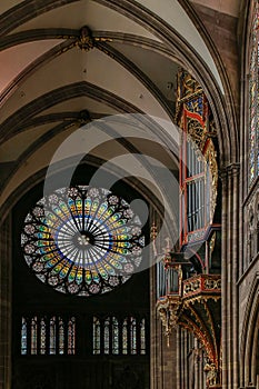 Rosette stained glass window by the interior of famous Notre Dame Cathedral de Strasbourg, France