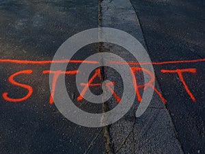 Strat line of street race. bright orange highlight letters spray painted on black asphalt photo