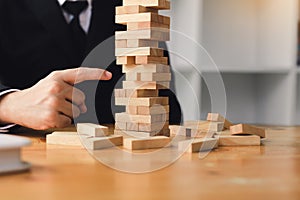 Strategic thinking and risk by business people pulls wooden blocks from the group