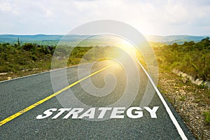 Strategy, concept photo of asphalt road. Motivational inscription on the road going forward. The beginning of a new path. A