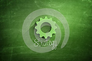 Strategy text with green cogwheel on blackboard