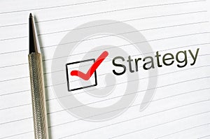 Strategy word written on lined paper. Strategy concept. Checkbox and pen