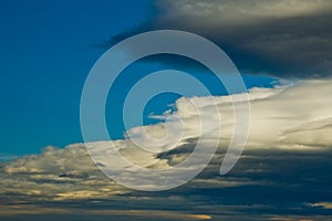 Stratus cloud formation rolling accross blue sky photo