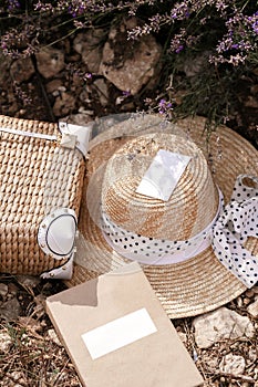 straw accessories,luxurious straw hat and bag lying on the groung in lavender field