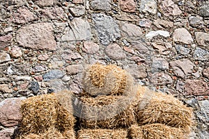 Straw bale on wall made of stones