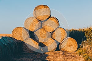 Straw bales on farmland in the sunset