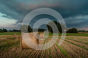 Straw bales in the field and cloudy sky