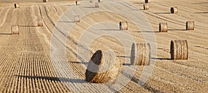 Straw bales in rolling hills of northern france under blue sky