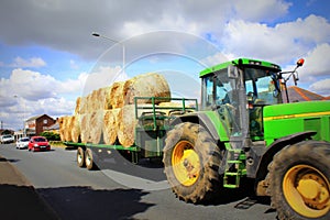 Straw bales tractor on countryside road UK