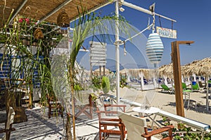 Straw beach umbrellas and sun chairs on a sandy beach on the east coast of Zakynthos island, Greece