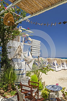 Straw beach umbrellas and sun chairs on a sandy beach on the east coast of Zakynthos island, Greece