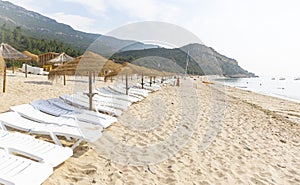 Straw Beach Umbrellas and sun loungers on Portinho da Arrabida Beach